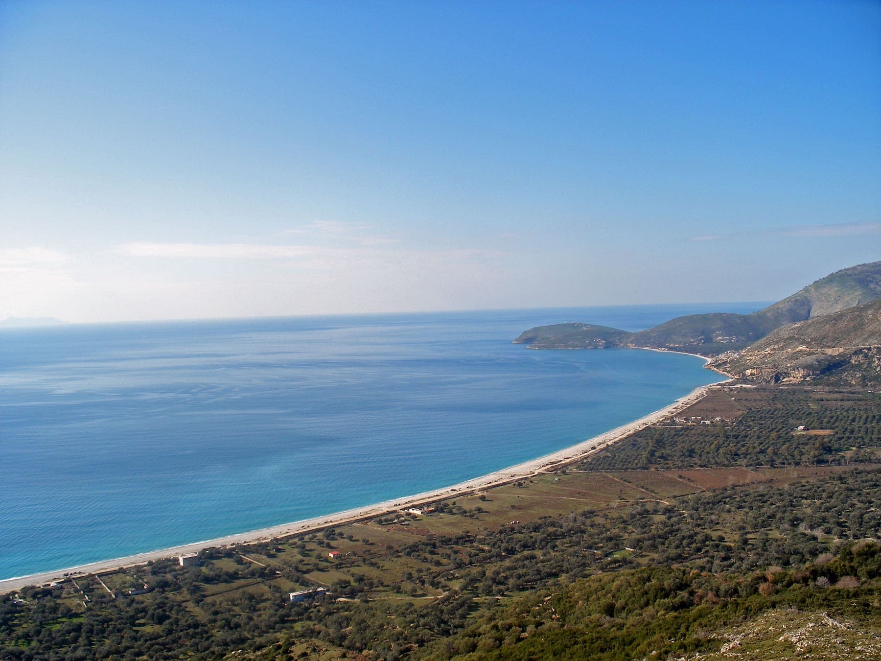 Ionian beach at Dhërmi with cliffs behind